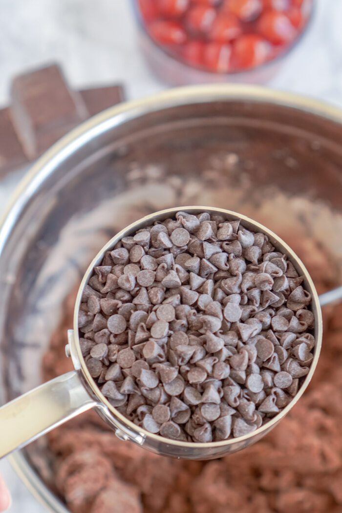 Chocolate chips being added to cookie dough