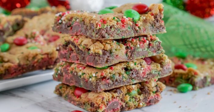 A stack of four Christmas-themed chocolate chip cookie bars.
