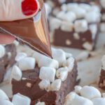 Drizzling chocolate over fudge square