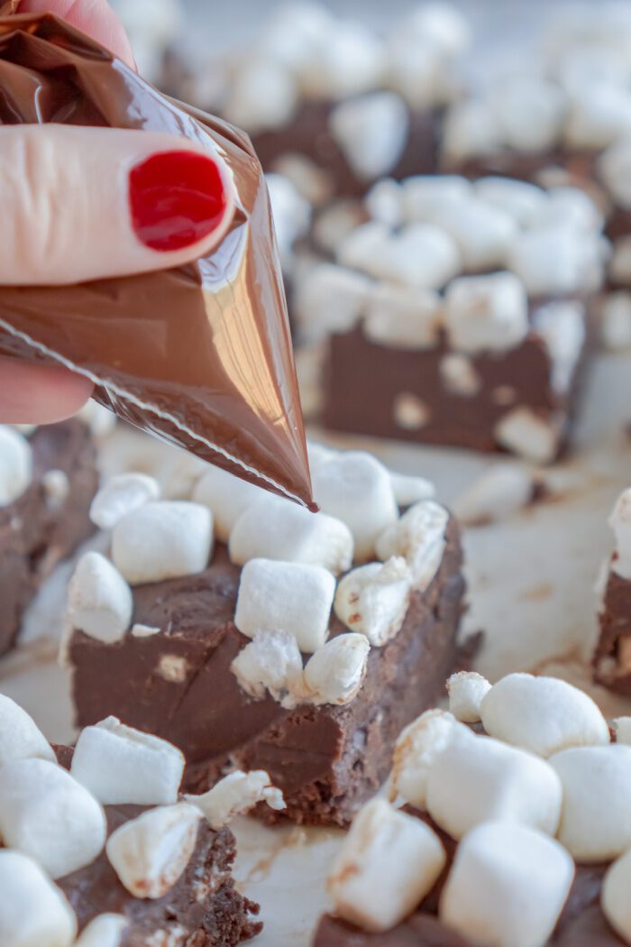 Drizzling chocolate over fudge square