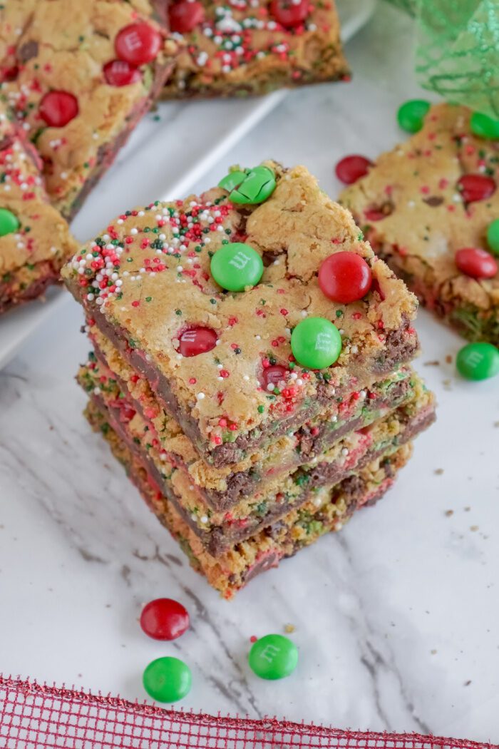 A stack of three Christmas-themed sugar cookie bars.
