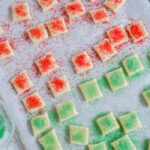 Mini cookies with sprinkles on baking sheet