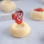 Pouring jam in hole of cookie dough ball