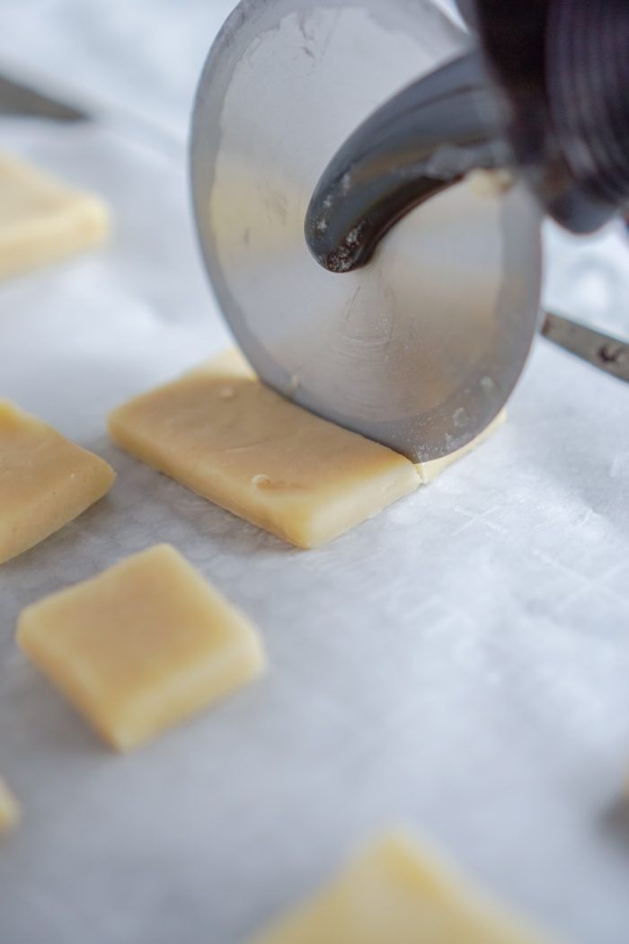 Slicing cut out cookies into mini square cookies