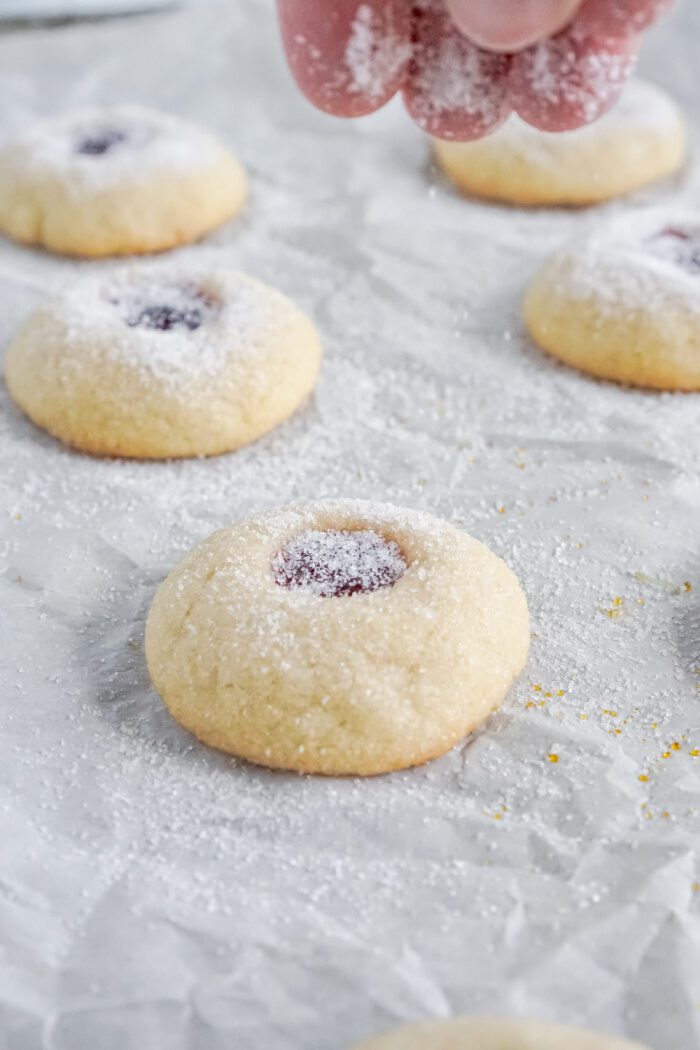 Sprinkling sugar onto baked cookie