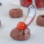 Topping cookie dough ball with cherry