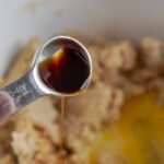 Vanilla and egg being added to mixing bowl