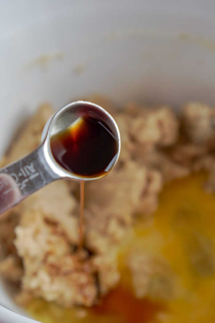 Vanilla and egg being added to mixing bowl