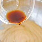 Vanilla being poured into mixing bowl