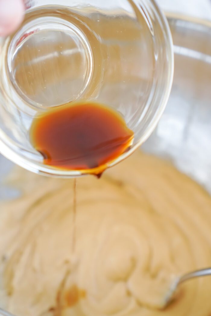 Vanilla being poured into mixing bowl