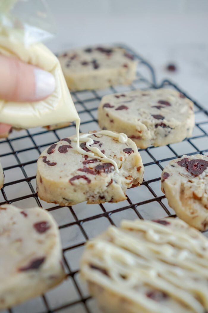 White chocolate being drizzled on cookie