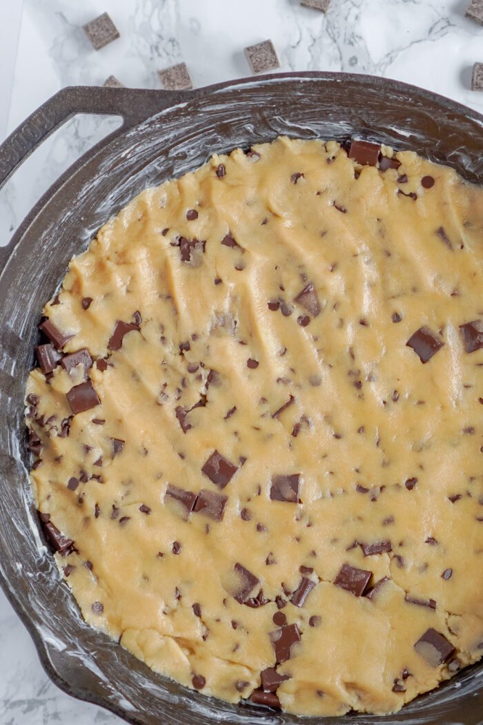 Chocolate Chip Cookie Dough Pressed Into the Cast Iron Skillet