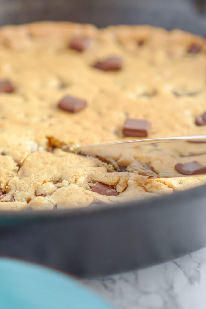 Chocolate Chip Skillet Cookie Being Cut Into