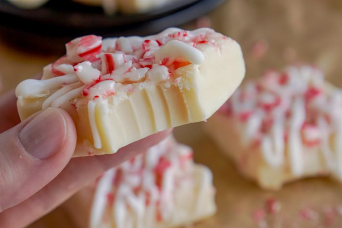 Someone Holding a Peppermint Fudge Square With a Bite Taken Out