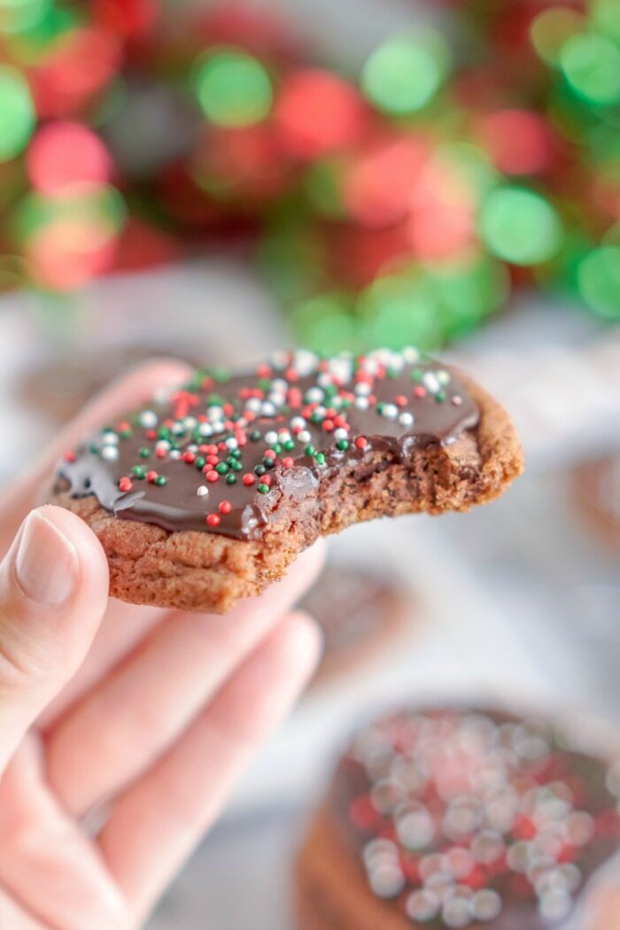 Someone Holding a Triple Chocolate Cookie With a Bite Taken Out