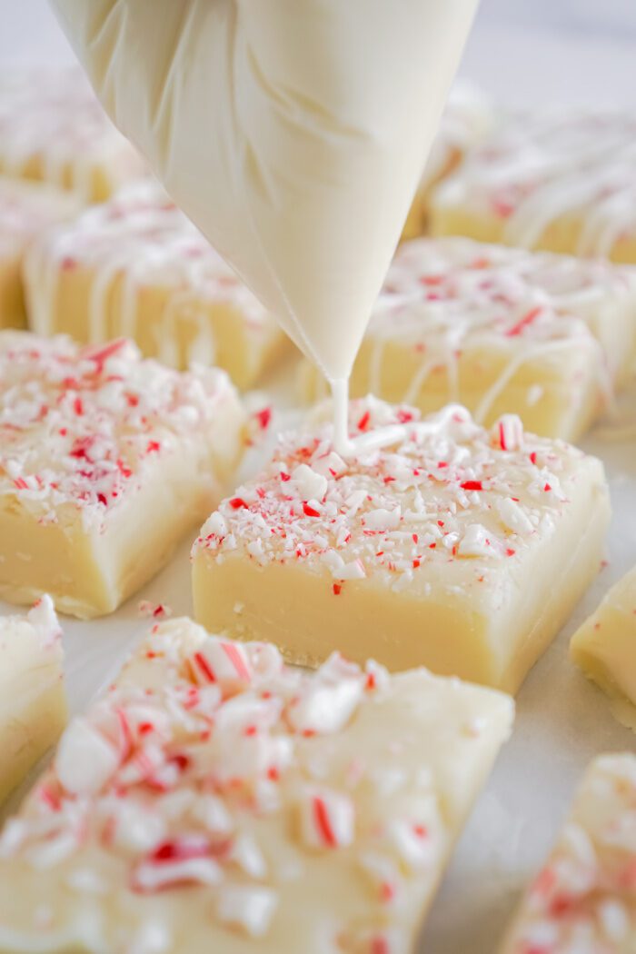 White Almond Bark Being Drizzled Over Fudge Squares