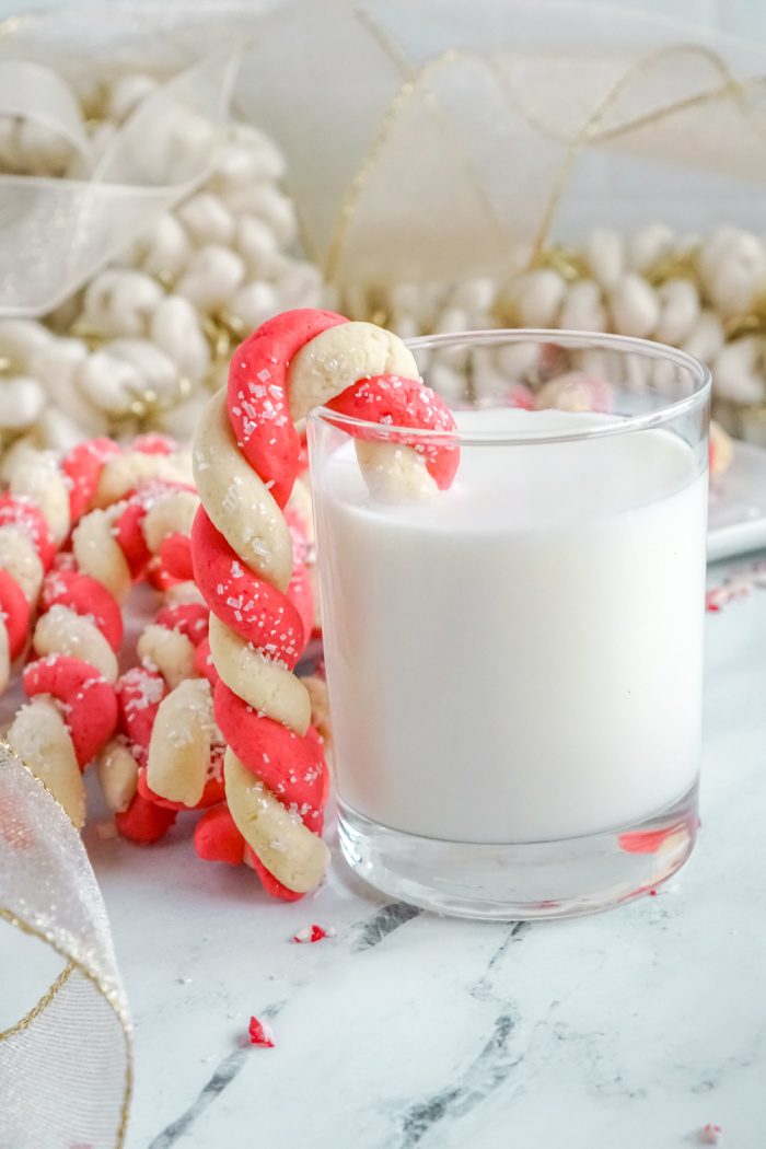 Candy Cane Sugar Cookie hanging on a glass of milk