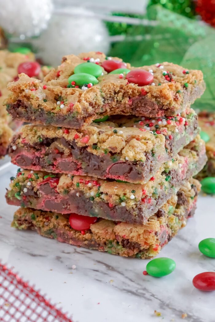 A stack of four Christmas-themed chocolate chip cookie bars.