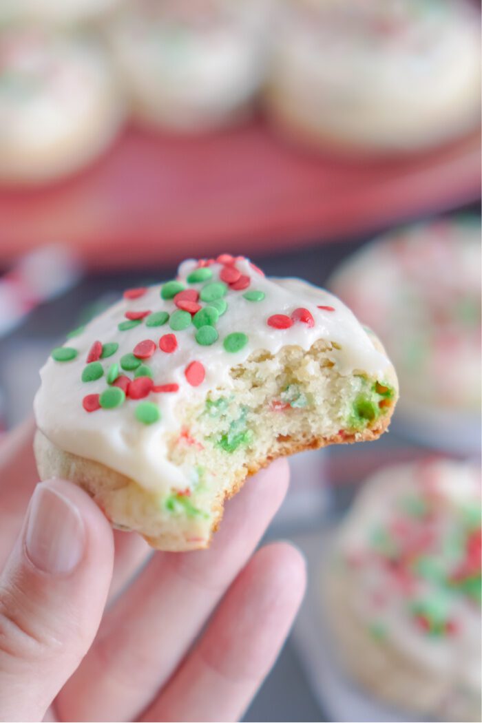 Someone holding a Sugar Cookie with a bite taken out of it