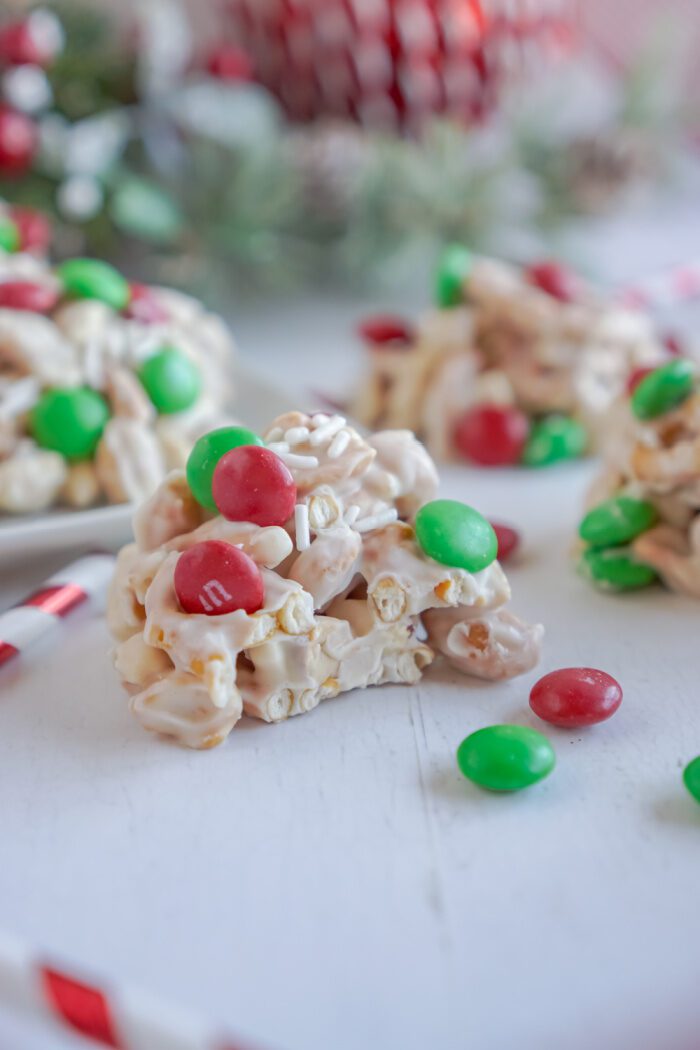 A scoop of White Chocolate Pretzel Crockpot Christmas Candy with a bite taken out