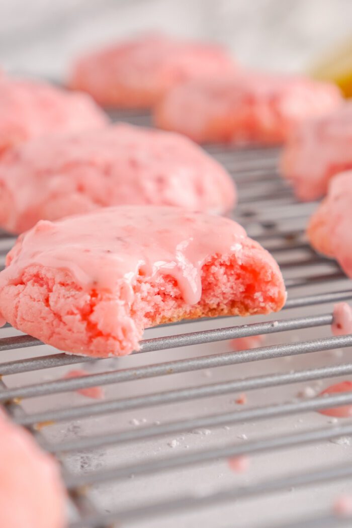Baked Strawberry cookie with a bite taken out on a cooling rack