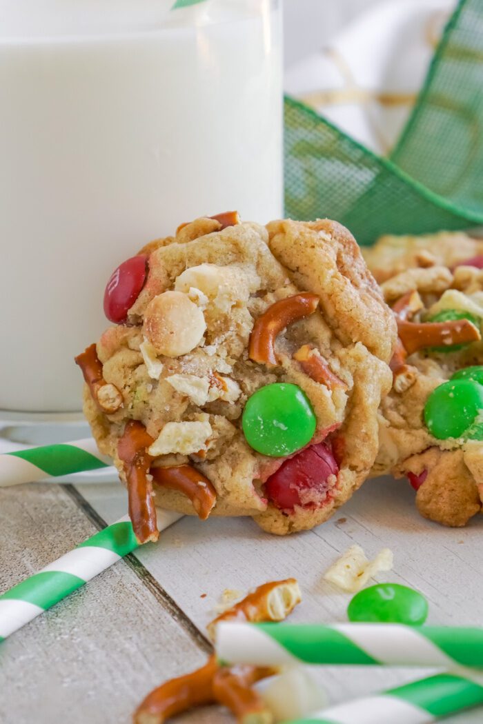 Close up of a Kitchen Sink Christmas Cookie propped up against a glass of milk