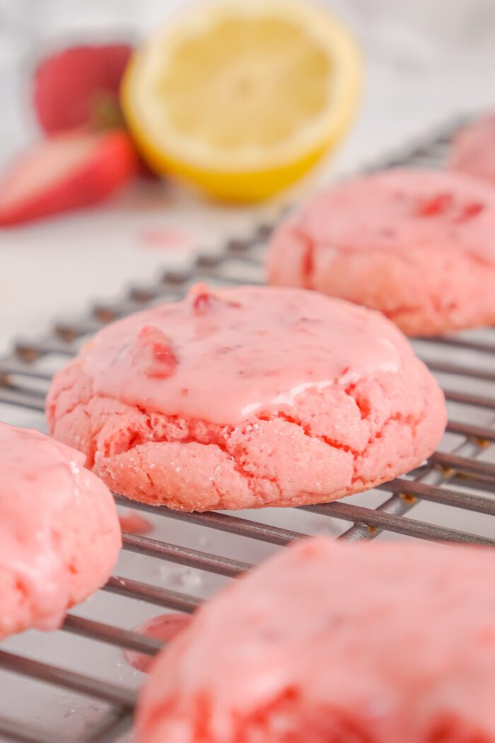 Close up of glazed Strawberry Cake Mix Cookie on cooling rack