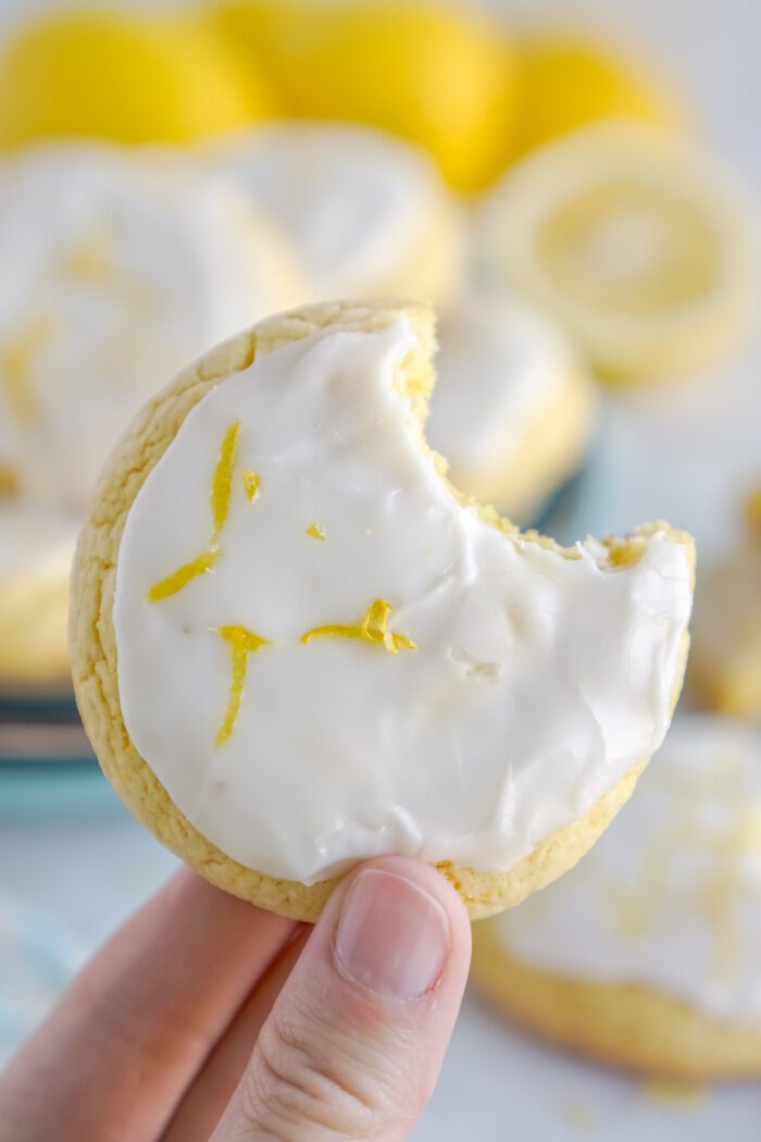 Someone holding a Lemon Cake Mix Cookie with a bite taken out of it