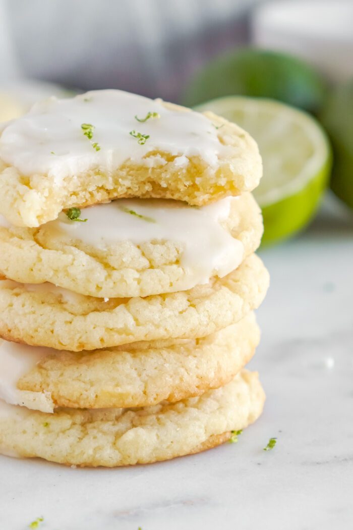 A stack of four lime sugar cookies with white icing.