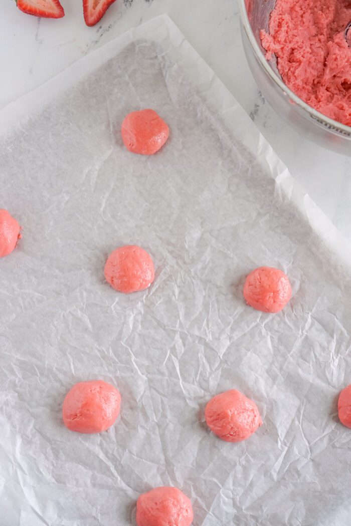 Strawberry Cake Mix Cookie dough balls on a prepared baking sheet