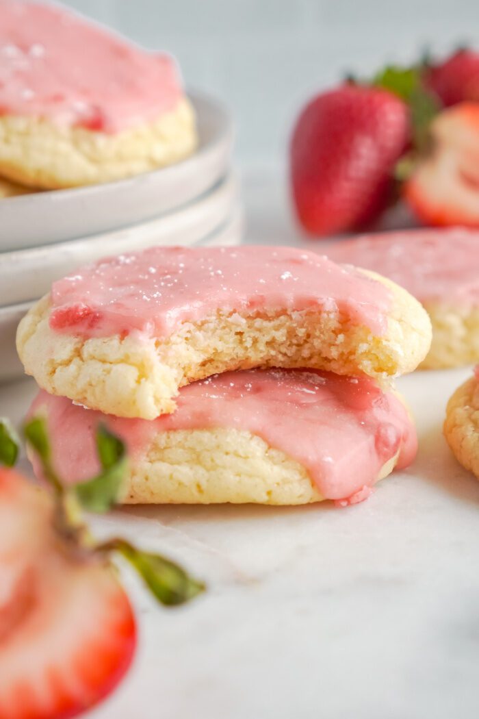 A close-up image of two strawberry sugar cookies with pink icing.
