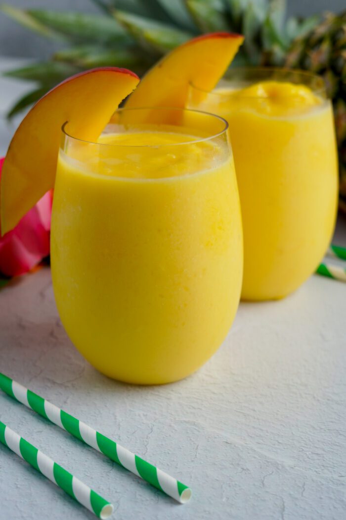 2 glasses of Mango Smoothies with Mango Slices in them