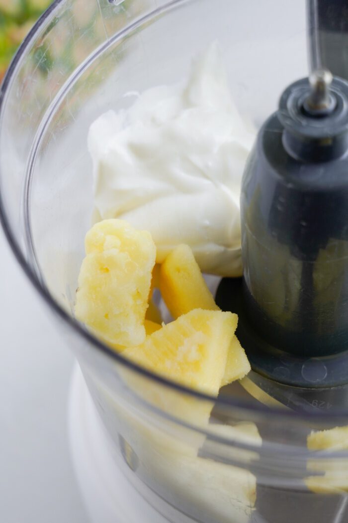 Frozen pineapple, yogurt, and ice in blender