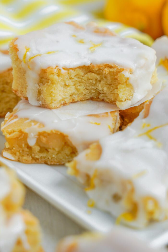 Stack of Lemon Sugar Cookie Bars with a bite taken out of the top one