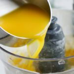 Orange juice being poured into blender