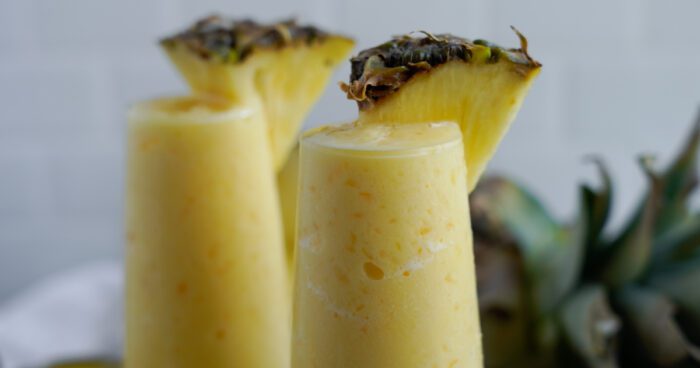 Wide view of 2 glasses of pineapple smoothie