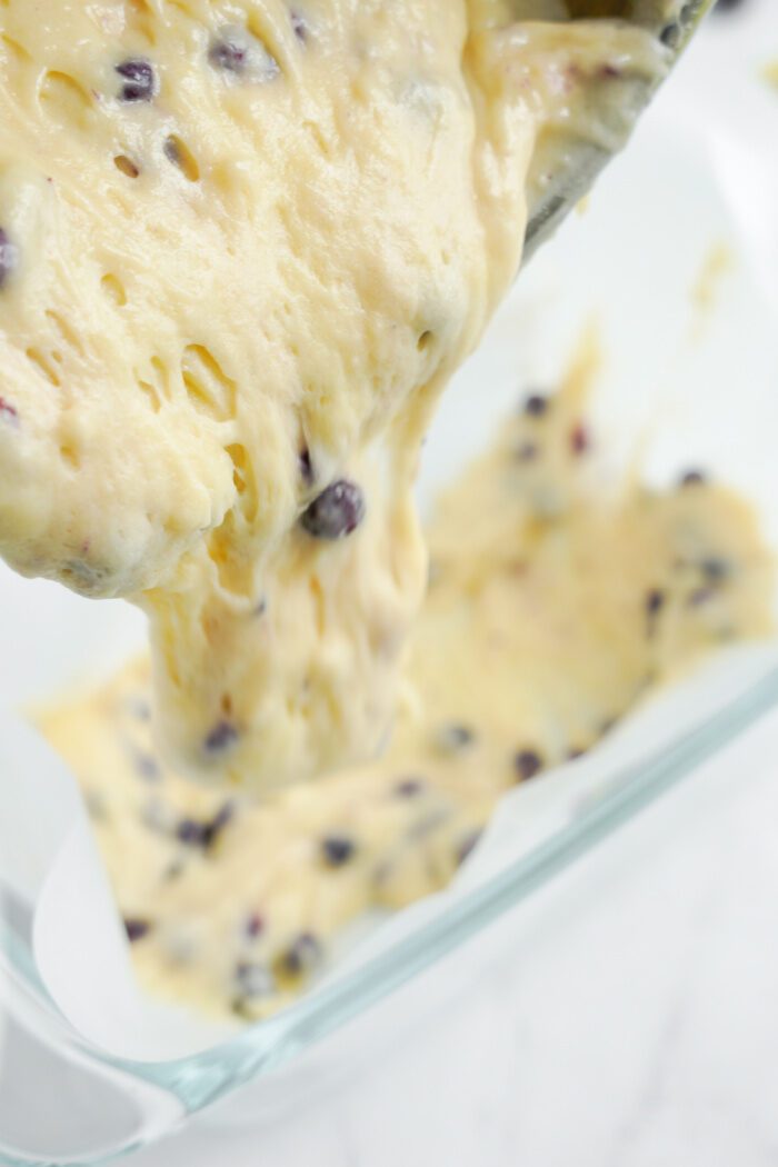 Pouring lemon blueberry batter into a pan