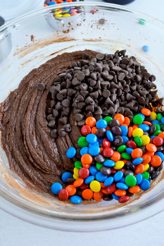 Chocolate chips and M&Ms added to bowl