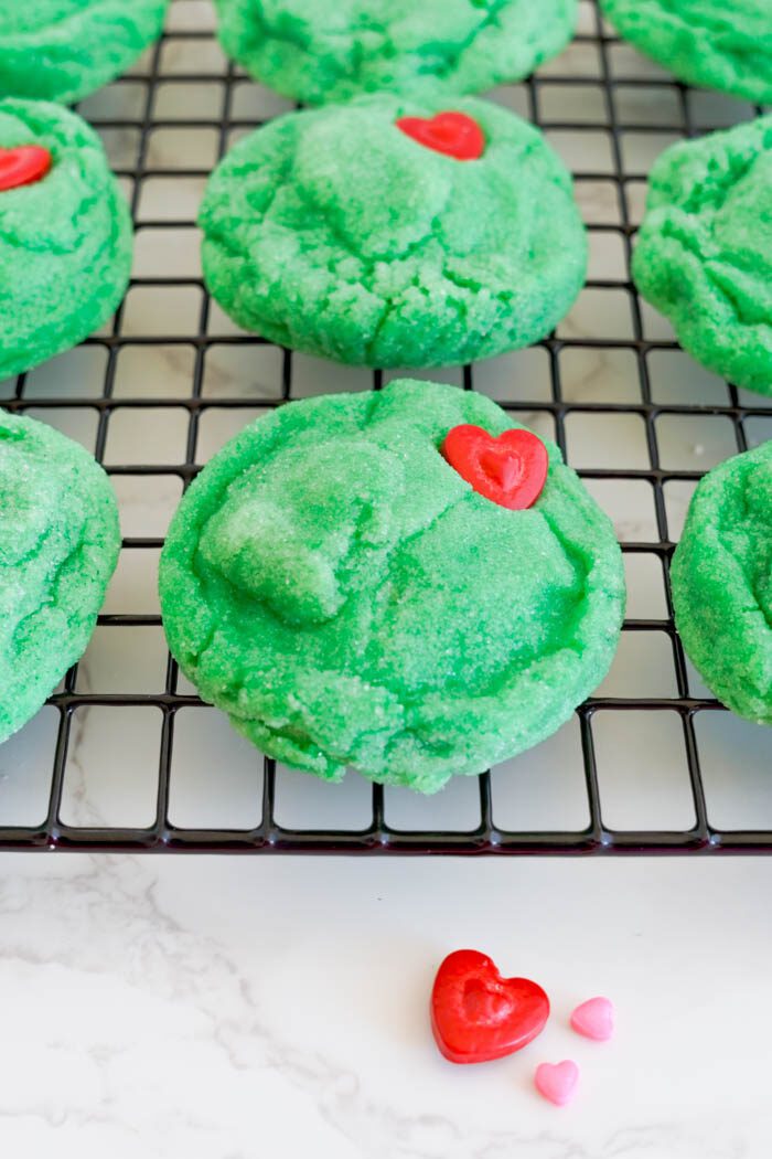 Green sugar cookies with red heart candies.