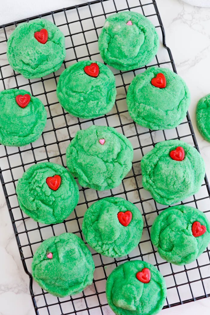 Green cookies with red heart-shaped sprinkles.