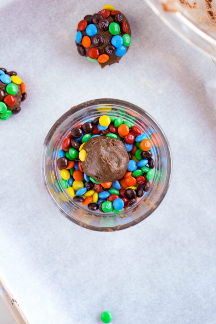 M&M cookie dough ball in a bowl of M&Ms