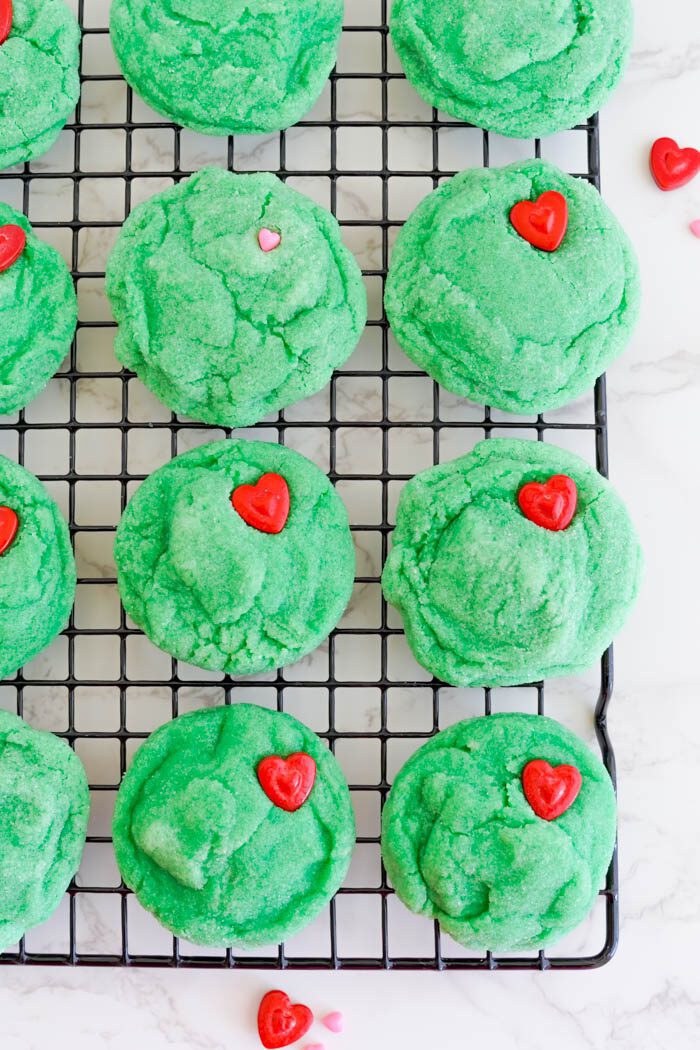 Green sugar cookies with red heart candies.