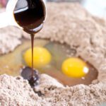 Vanilla being poured into mixing bowl