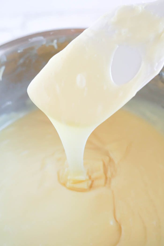 White viscous liquid being poured from a ladle.