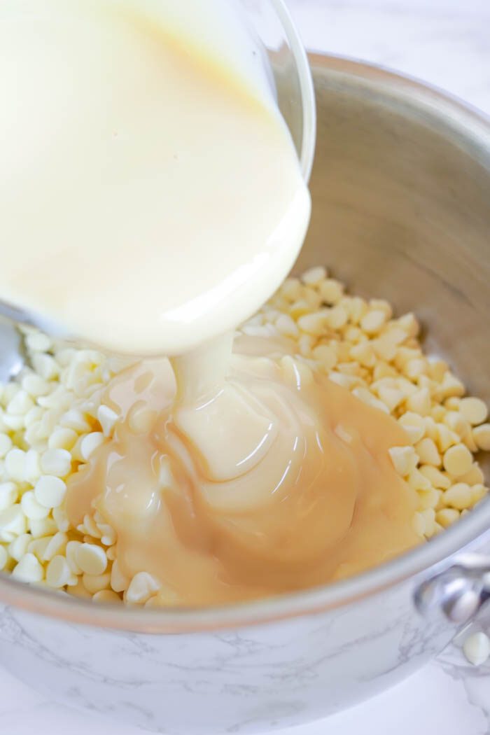 White chocolate chips being poured into a bowl.