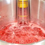 Boiling candy mixture in pot with candy thermometer