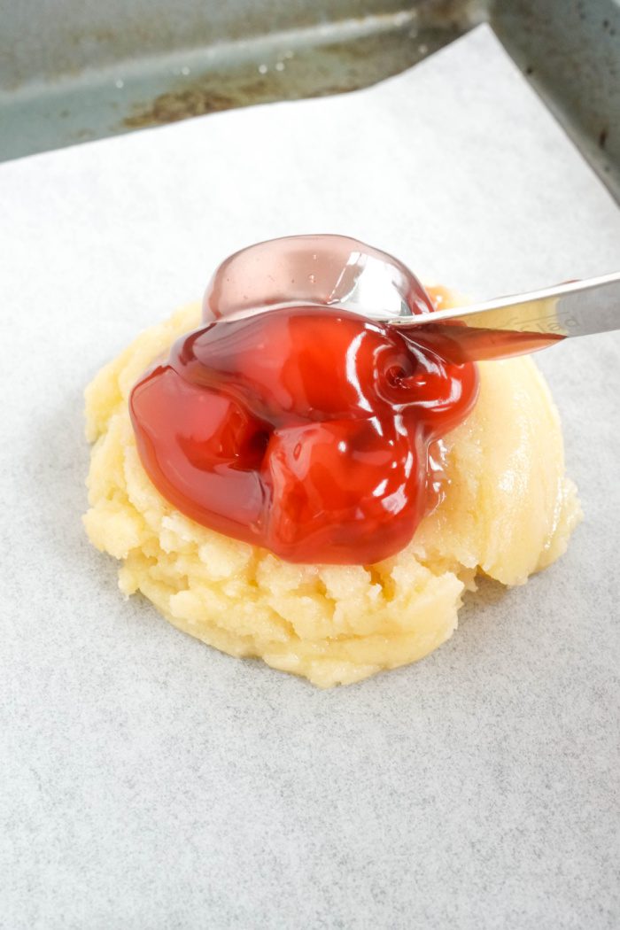 Cherry pie filling on top of cookie dough balls