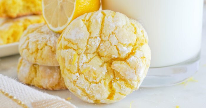 Wide view of Lemon Crinkle Cookie propped against a glass of milk