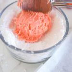 Rolling cookie dough ball in powdered sugar