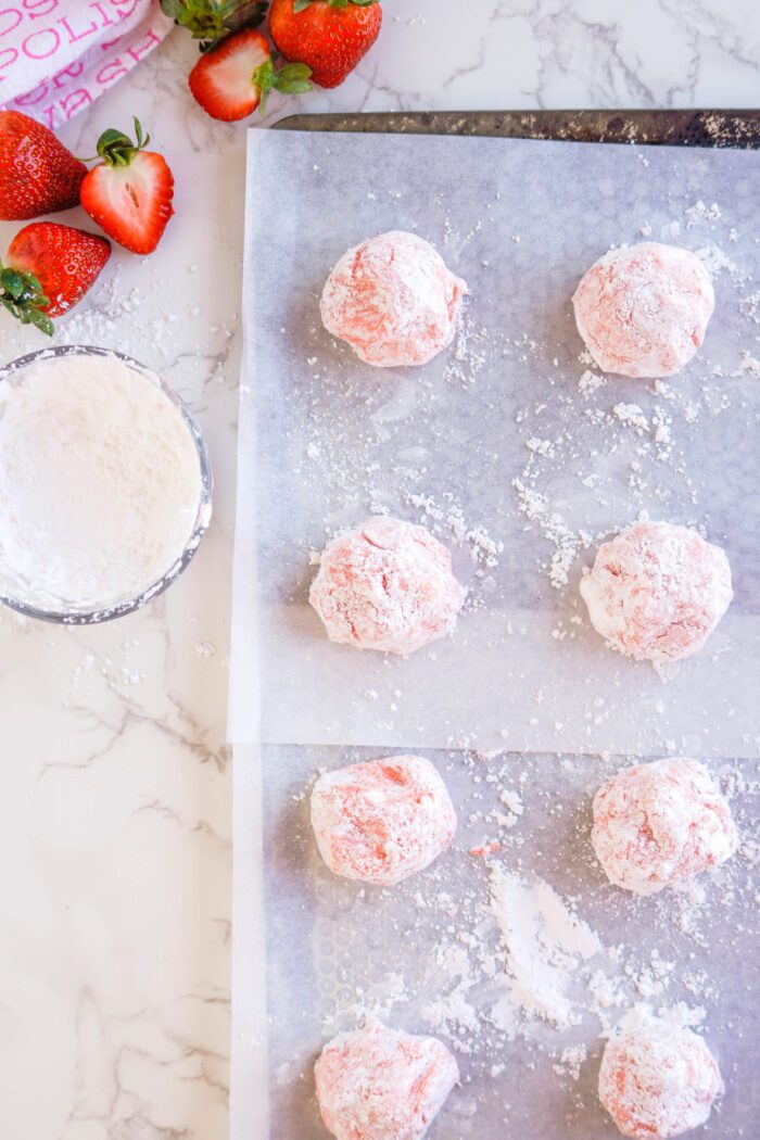 Strawberry cookie dough balls on a baking sheet